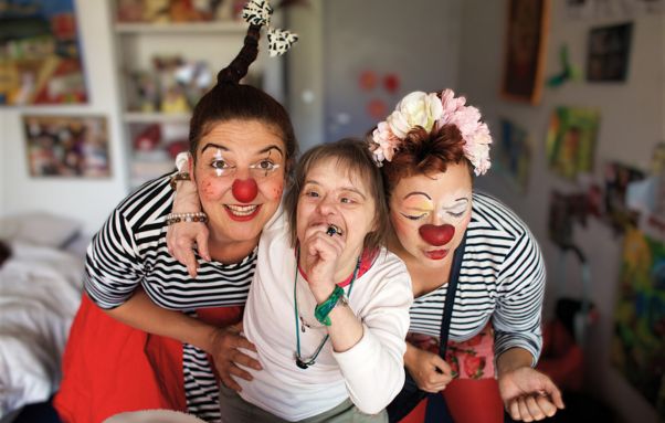 Duo de clowns jouant avec une bénéficiaire dans un établissement spécialisé